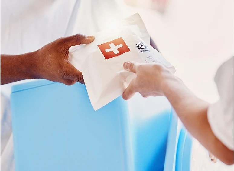 A person hands over a package with a Swiss flag symbol.