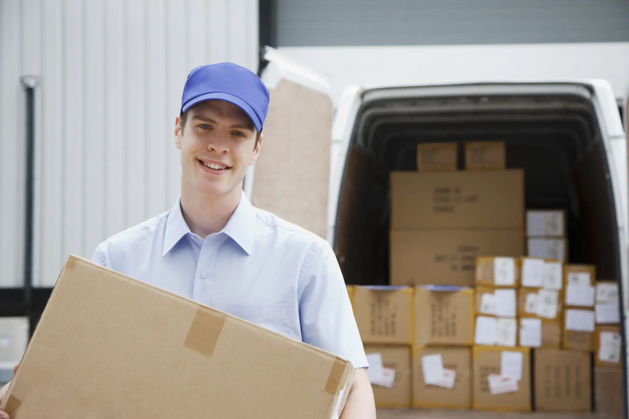 Delivery person holding a package and smiling.